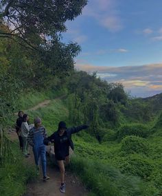 several people walking up a hill on a trail