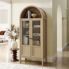 a tall wooden cabinet sitting in the corner of a living room