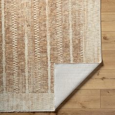 an area rug with wood flooring on top of it and a wooden floor in the background