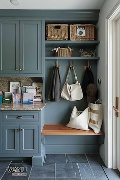 an entry way with blue cabinets and white bags on the bench, along with two purses