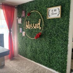 there is a green wall with the word blessed on it and red roses in the middle