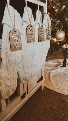 christmas stockings hanging from hooks in front of a tree