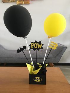 some balloons are in a black box with yellow and black stickers on them that say pow