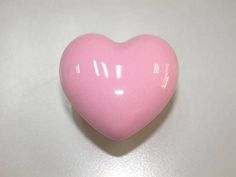 a pink heart shaped candy sitting on top of a table