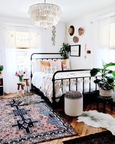 a bed room with a neatly made bed and rugs