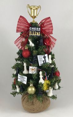 a small christmas tree decorated with ornaments and ribbons is shown in front of a white background