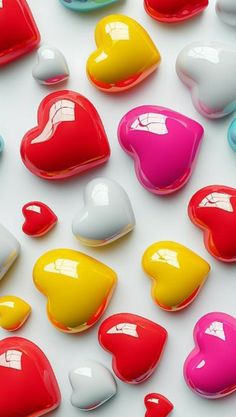 many different colored hearts on a white surface