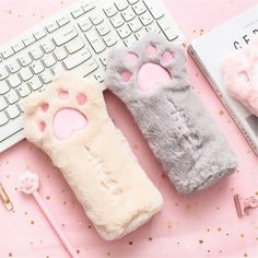 two furry cat mittens sitting next to a keyboard