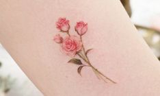 a small pink rose tattoo on the thigh