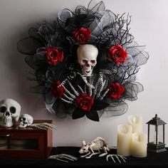 a skeleton with roses on it's head sitting in front of a wreath and candles