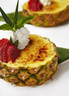 two pineapples with whipped cream and strawberries on top