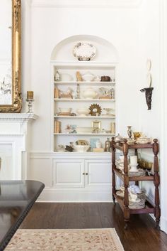 a living room filled with furniture and a fire place next to a wall mounted clock