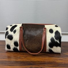 Perfect for travelers who value durability and timeless design, this set cowhide duffle bags offers ample storage and a unique aesthetic that stands out in any setting. - Free shipping on all cowhide duffle bags. - Large Duffel Bag Dimensions: 22" Length x 12" Height x 12" Width. - Small Duffel Bag Dimensions: 14" Length x 8" Height x 8" Width. - Water-resistant and scratch-resistant features ensure your belongings stay protected. - Each bag features a unique cowhide pattern, similar to the one shown in pictures. - Production time: approximately seven business days per cowhide bag. When it comes to combining luxury with functionality in travel accessories, few items can match the elegance and versatility of cowhide duffel bags. Ideal for both men and women, these bags offer not just a way Metallic Cowhide Rug, Brindle Cowhide, Leather Toiletry Bag, Leather Waist Bag, Real Leather Bags, Cowhide Bag, Cowhide Rugs, Leather Duffle Bag, Rattan Bag