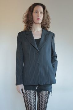 Best of 1990's classic minimalist cool Emporio Armani two button blazer. Great androgynous masculine style. Pin stripes on black background with white and grey stripes. Side front pockets. Fully lined. Slight shoulder pads give good shape to the shoulders. Label Emporio Armani, Made in Italy, Size 46. Dry clean only. 61% rayon, 30% pure wool, 5% nylon, 3% cotton, 1% polyester. Lining 100% rayon. Very good vintage condition with no fabric or sewing flaws. MeasurementsShoulders 44cm/ Chest 102cm/ Striped Single-breasted Blazer For Office, Classic Single-button Striped Blazer, Classic Pinstripe Blazer For Office Wear, Winter Striped Blazer For Business Casual, Classic Striped Blazer For Office, Pinstripe Single Breasted Blazer For Office Wear, Pinstripe Long Sleeve Blazer For Office, Classic Long Sleeve Blazer With Vertical Stripes, Office Blazer With Vertical Stripes And Long Sleeves