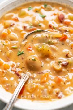 a white bowl filled with soup next to a spoon