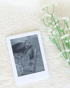 a white tablet sitting on top of a table next to some baby's breath flowers