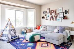 a living room filled with furniture and lots of pictures on the wall above it's windows