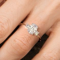 a woman's hand with a diamond ring on top of her finger and an engagement band