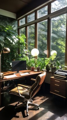 a desk with a computer and chair in front of large windows