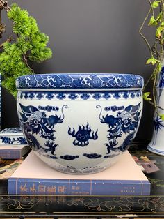 a blue and white bowl sitting on top of a table next to two vases