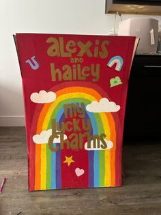 a wooden sign that says alex's and hailey with a rainbow in the background