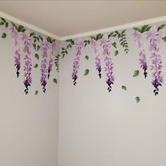 the wall is decorated with purple flowers and green leaves