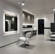 an empty salon with white chairs and mirrors