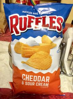 a bag of ruffles chips sitting on top of a table next to a knife