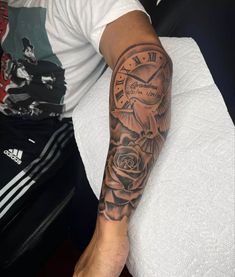 a man's arm with a clock and rose tattoo on the left side of his arm