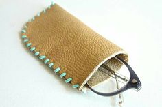 a pair of eyeglasses resting in a leather case on a white table top