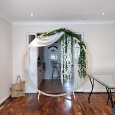 a room with a table, chairs and a mirror on the wall that is decorated with white flowers