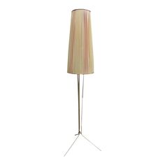 a floor lamp with a beige shade on it's side and a white background