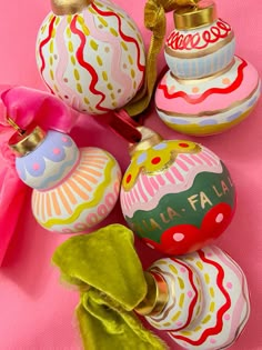 some ornaments are sitting on a pink surface