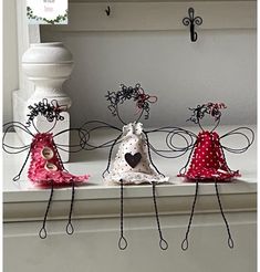 three little angel figurines sitting on top of a window sill