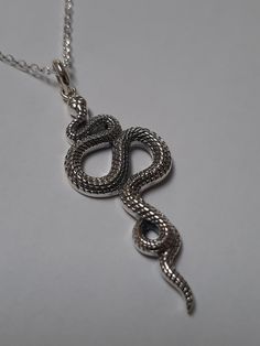 Impresionante colgante de plata esterlina con forma de serpiente, muy real y con una forma muy orgánica. La serpiente está muy detallada, magníficamente proporcionada y la piel tiene todas sus escamas. La cadena de plata de 50 cm está incluida en el precio. Impressive sterling silver pendant in the shape of a snake, very real and with a very organic shape. The snake is very detailed, superbly proportioned, and the skin has all its scales. The 50 cm long silver chain is included in the price. Metal Snake Shape Necklace As Gift, Silver Snake Necklace With Symbolic Style, Gift Sterling Silver Snake Necklace, Handmade Silver Snake Necklace, Handmade Silver Snake Shape Necklace, Adjustable Metal Snake Shape Necklace, Spiritual Silver Snake Necklace, Symbolic Snake-shaped Necklace For Gift, Serpent Necklace Silver