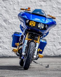 a blue motorcycle parked next to a white wall