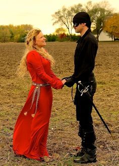 a woman in a red dress and a man in black