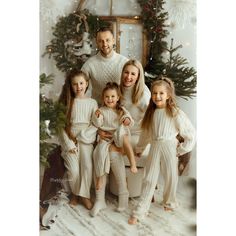 a family posing for a christmas photo in front of a tree