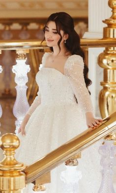 a woman in a white dress is standing on the stairs