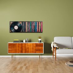 a living room with a couch, sideboard and record player on the green wall