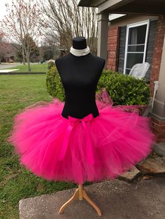 a mannequin wearing a pink tutu with a black top and pearls on it