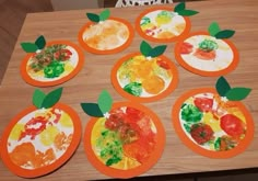 paper plates with fruit painted on them sitting on a table