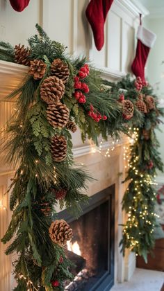 a fireplace decorated for christmas with pine cones and greenery hanging from the mantel