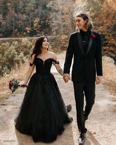 a man in a tuxedo and a woman in a black dress holding hands