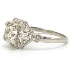 The perfect Art Deco engagement ring! An archetypically off-round Old Mine Cut diamond is prong set sideways and flanked on either side by a bezel set baguette. Outlining the entire ring are fourteen round brilliants, bringing the ring's total carat weight to 2.19 ct. Generously sized and replete with dazzling diamonds, this stunning piece is in immaculate condition. We must say, it is rare to find a high color, high clarity stone and have it be an old fashioned cut. When the modern brilliant first arrived, a lot of people took their good diamonds and had them recut in an effort to modernize their jewelry. This is really a treasure. Metal: Platinum Main Stone: 1 Old Mine Cut Diamond (1.75ct, G color, VS2 clarity) Ring Size: 7.5 (can be sized) Old Mine Cut Diamond, Art Deco Engagement, Deco Engagement Ring, Art Deco Engagement Ring, European Cut Diamonds, Platinum Ring, Best Diamond, Baguette Diamond, Prong Setting