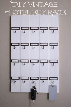 a white wall mounted to the side of a building with keys hanging from it's hooks