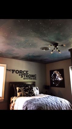 a bedroom with a ceiling painted to look like the force is strong star wars theme