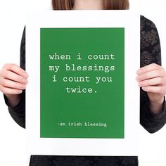 a woman holding up a green poster with the words when i count my blessing, i count you twice