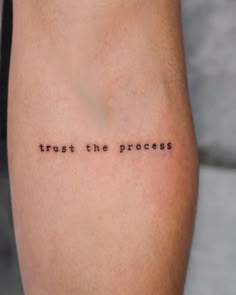 a tattoo saying trust the process on someone's leg with words in black ink