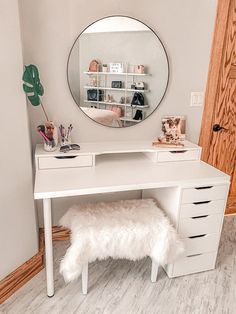 a white desk with a mirror and stool